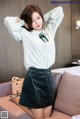 a woman in a white shirt and green skirt posing on a couch