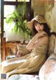 A woman sitting on a couch wearing a straw hat.