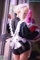 A woman dressed as a maid holding a tray of food.